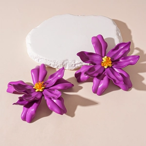 Detailed macro view of purple flower earrings with beaded stamens and a glossy finish