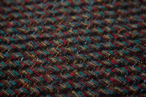 Macro view of colorful herringbone weave texture on a thick wool blend scarf
