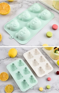 Detail of 6-cavity panda silicone cake mold in green and white on marble surface