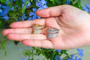 Close-up of gold and silver irregular twisted star rings with micro-set zircons on hand