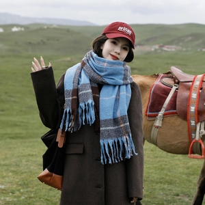 Plaid tassel scarf in blue and brown colorway worn in a scenic outdoor setting