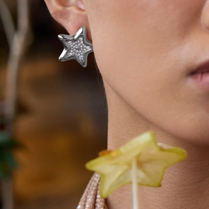 Élégantes boucles d'oreilles étoiles argentées avec strass brillants sur le mannequin