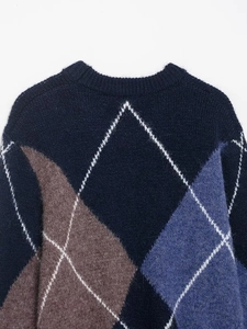 Detail of the navy blue and brown argyle knit pattern on the warm autumn sweater