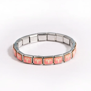 Detail of Italian charm bracelet links featuring pink Aries zodiac sign symbols on stainless steel