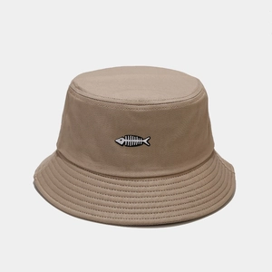 Detailed close-up of khaki bucket hat featuring a black and white fish bone embroidery