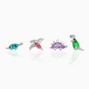 Detail of four dinosaur stud earrings with colorful zircon stones in silver finish