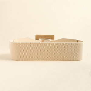 Detail of beige elastic waist belt featuring a polished rectangular gold buckle closure