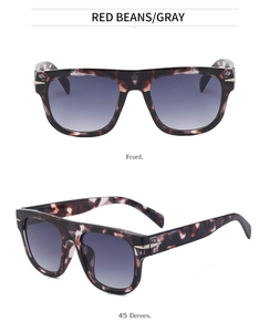 Detail view of tortoiseshell oversized sunglasses with gray gradient lenses and metal trim