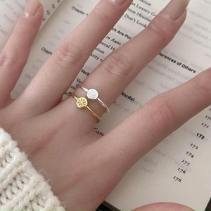 Detail of minimalist 925 sterling silver starburst rings worn in a cozy scene