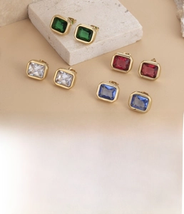 Close-up of titanium steel stud earrings featuring colorful rectangular cubic zirconia