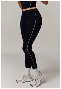 Detalle de leggings negros de cintura alta con rayas blancas laterales y ajuste de compresión