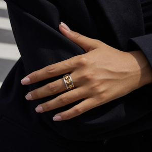 Close-up of dual-tone stainless steel ring with sun, moon, and star celestial motifs