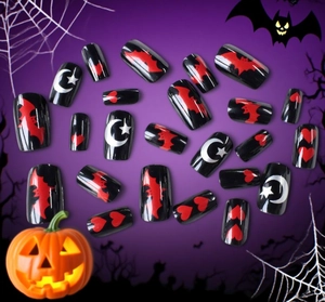 Detail of Halloween press-on nails featuring red bats and stars on glossy black finish