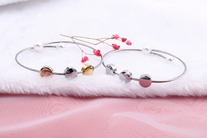 Three-color steel cable bracelets with pearls in gold, silver, and rose gold finishes