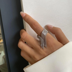 Detailed close-up of a silver beaded tassel ring with dangling metal chains and texture
