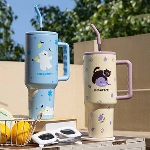 Outdoor picnic setup featuring blue and beige tumblers with handles and straws