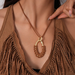Detailed shot of bohemian brown suede cord necklace with a golden geometric pendant
