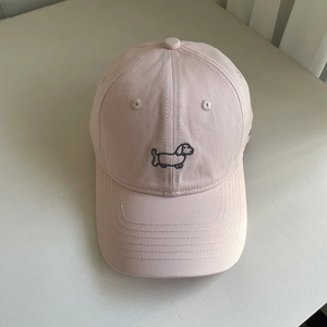 Close-up of pink cotton canvas baseball cap featuring a blue dachshund embroidery detail