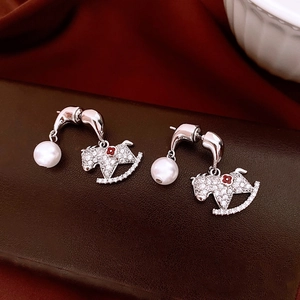 Vue détaillée de boucles d'oreilles cheval à bascule avec cristaux et perles