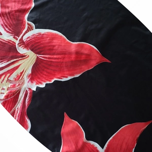 Close-up of floral print fabric detail with red flowers on black polyester dress