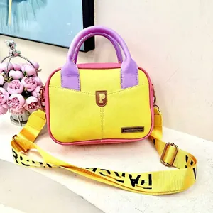 Macro shot of pebbled leather texture with yellow and purple color block design on a handbag