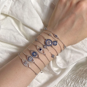 Nahaufnahme des S925 Silber Evil Eye Armbands mit blauen Zirkonia auf Seidenstoff