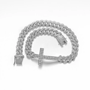 Close-up of silver-plated iced out Cuban link bracelet with a sparkling cross charm