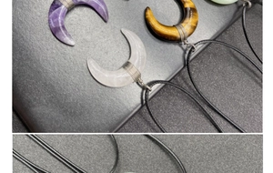 Detailed close-up of crescent moon pendants wrapped in wire with various natural gemstones