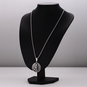 Vintage silver stainless steel necklace with round praying hands pendant on a model