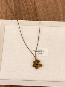 Detail of flower pendant necklace with tiger eye stone finish on a brown cord