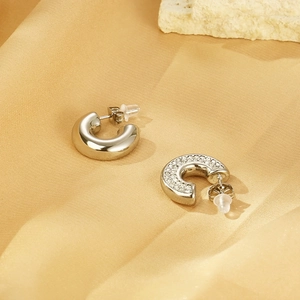 Detailed view of silver hoop earrings with polished finish and pavé settings on satin