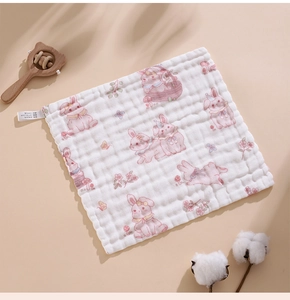 Detail of soft 100% cotton baby gauze towel with cute pink rabbit print and wavy edges