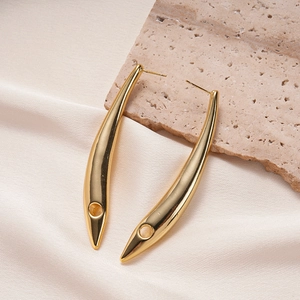 Detailed close-up of curved 18K gold-plated bar earrings with circular hollow detail