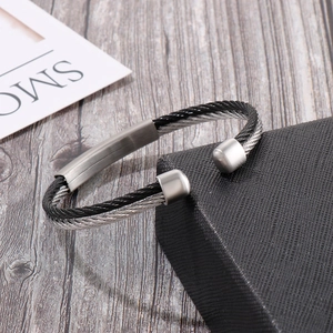 Detail of twisted cable cuff bracelet with brushed metal plate and silver-black finish
