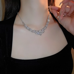 Gros plan du collier à pampilles en diamants au design de feuille en U sur un modèle