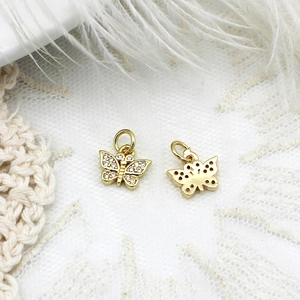 Detailed close-up of micro-pave gold butterfly charms with sparkling crystals