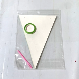 DIY soccer party banner kit with white triangular flags, green tape, and pink plastic needle