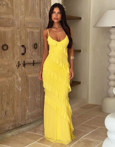 Detail of elegant yellow backless dress featuring layered ruffles and a side slit