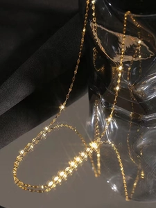 Macro shot of gold double layer blade snake chain necklace with reflective mirror finish
