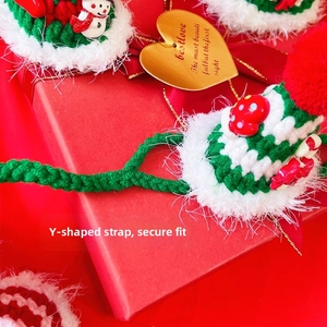 Detail of hand-knitted Christmas pet hat with Y-shaped strap and festive 3D ornaments