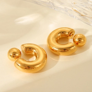 Detailed view of chunky golden C-shaped hoop earrings with unique spherical backings