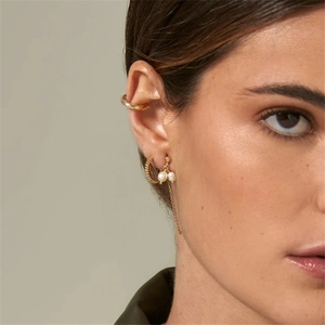 Detail of s925 silver tassel chain pearl earrings and golden ear cuff on a model's ear
