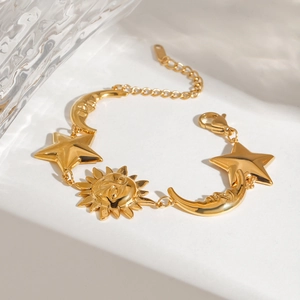 Detail view of 18K gold plated stainless steel celestial sun moon and star charm bracelet