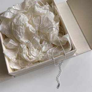 Close-up of S925 sterling silver snake bone chain necklace in a beige gift box display