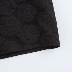 Detail des schwarzen Jacquard-Minikleids mit 3D-Blumenstruktur und Puffärmeln