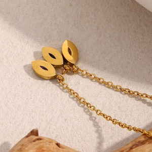 Macro detail of 18K gold-plated necklace featuring three evil eye zircon pendants