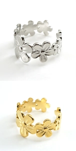 Detail of hollow floral stainless steel rings in polished gold and silver finishes