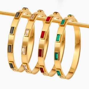Elegant gold stainless steel bangles with colorful zircon stones on display stand