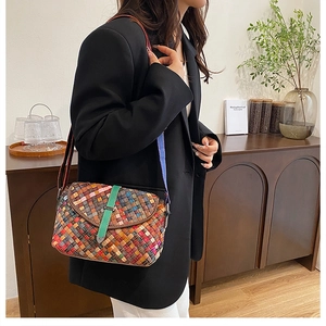 Détail du sac oreiller tissé à la main avec boucle en cuir vert porté par un mannequin