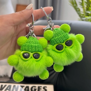 Porte-clés en peluche verte avec chapeaux tricotés et lunettes de soleil tendance